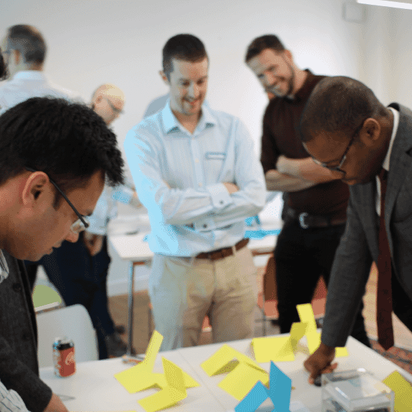 Group of professionals collaborating around a table during a workshop, supporting building a cohesive and empowered leadership culture.