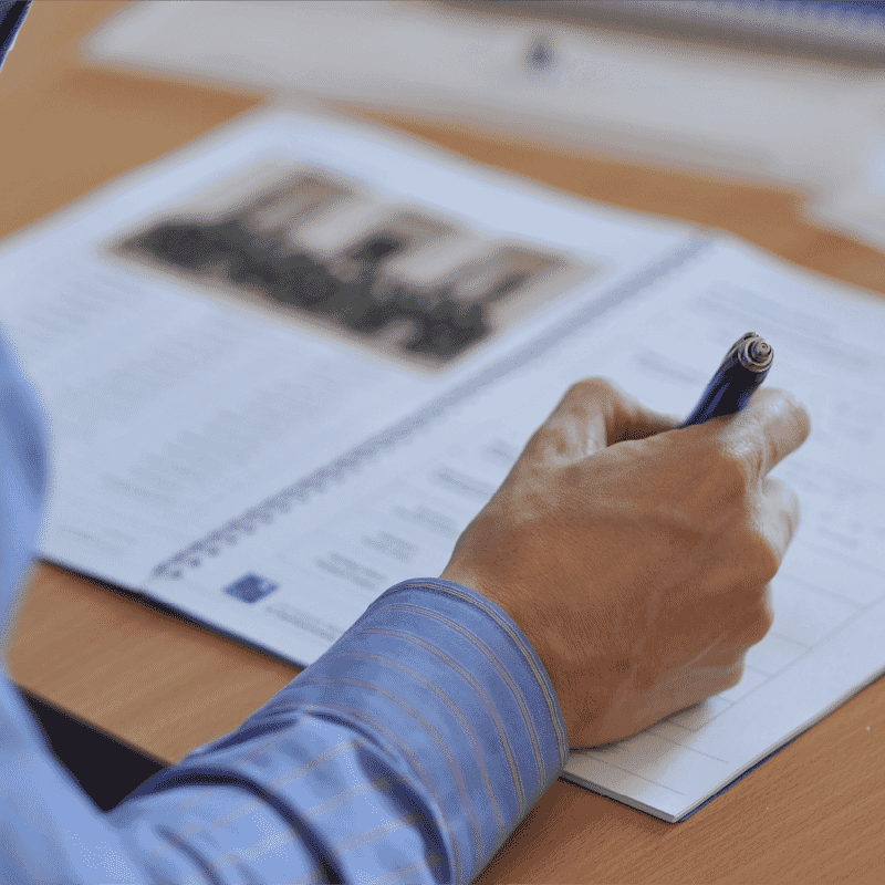 Participant writing in a leadership development workbook during a workshop on developing high performing leaders.