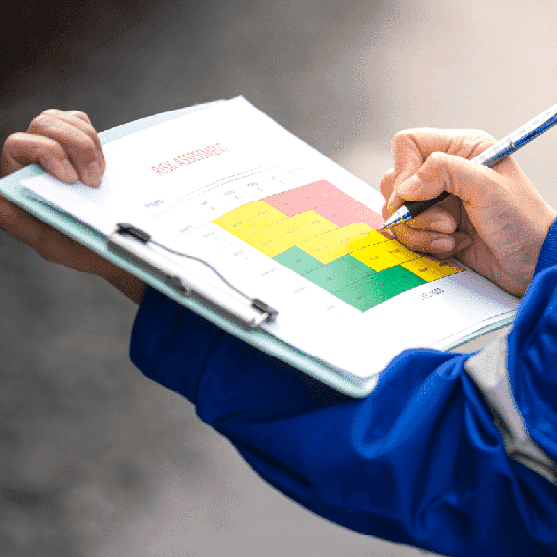 Hands reviewing a color-coded risk assessment matrix on a clipboard as part of Developing Resilient Incident Leaders training.