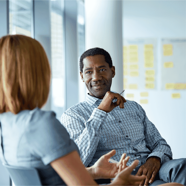 a photo of a man coaching a woman in a business setting