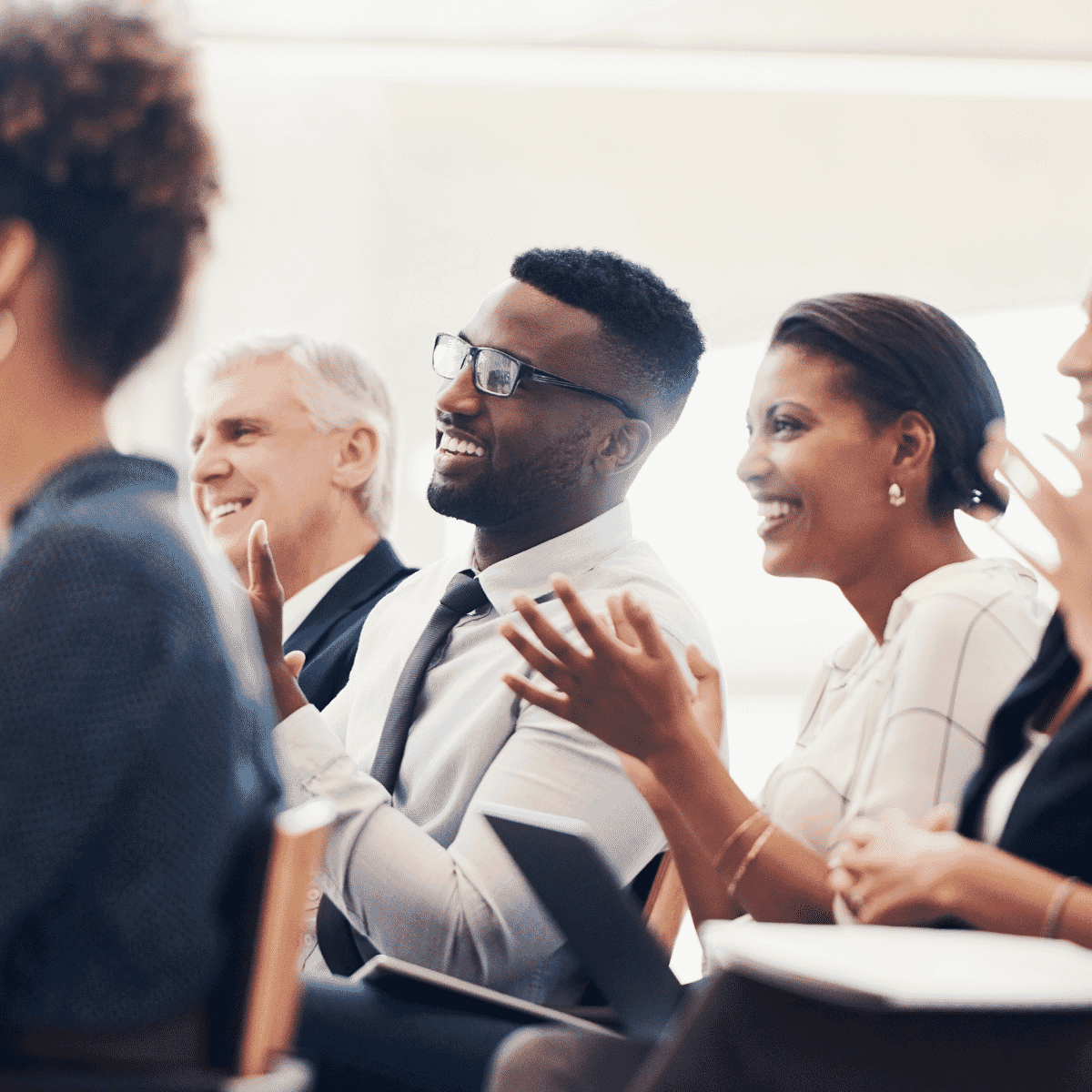 A diverse group of business professionals applauding during a meeting